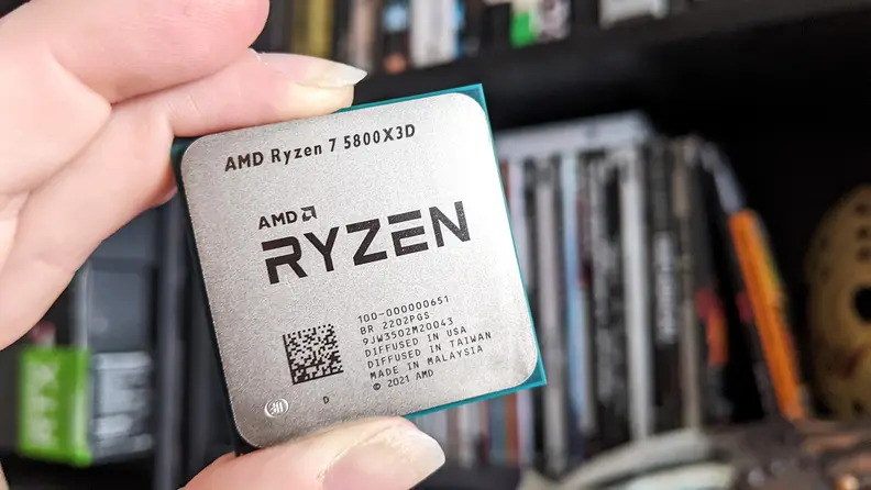 A close up of a desktop processor being held between someone's fingers