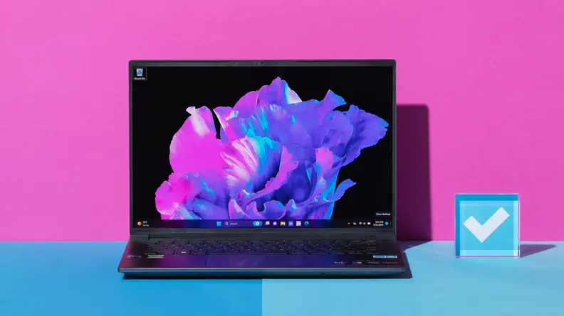The Acer Swift X 14 on a blue table with a pink background.