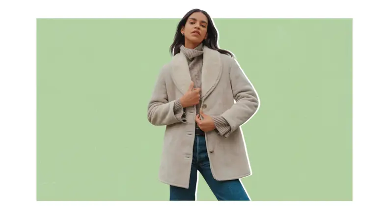 A model wearing a gray shearling peacoat-style coat.