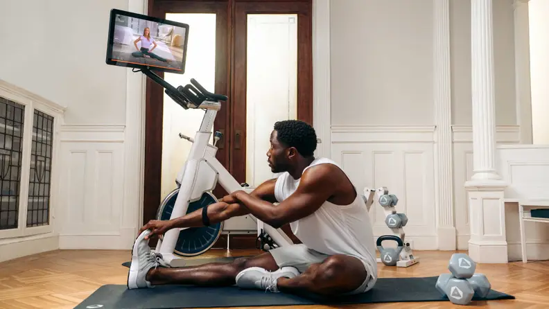 A man stretching next to the Myx II.