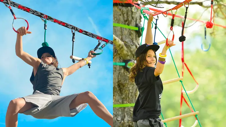 Two children hang on a rope course.
