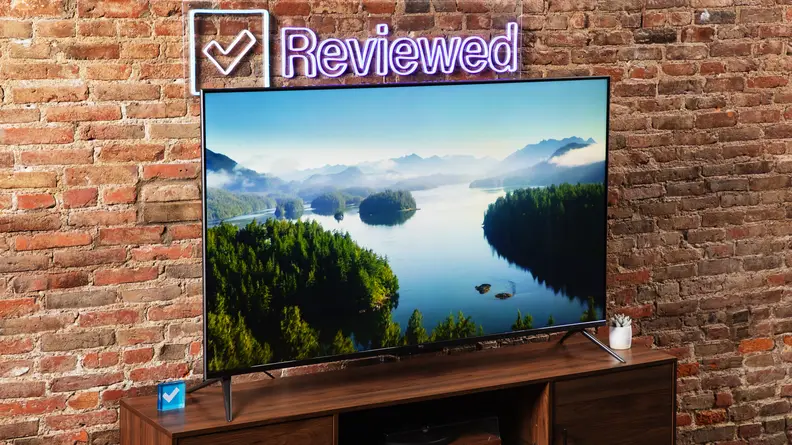 The Amazon Fire TV Omni on a wooden table displaying a river winding through a forest.