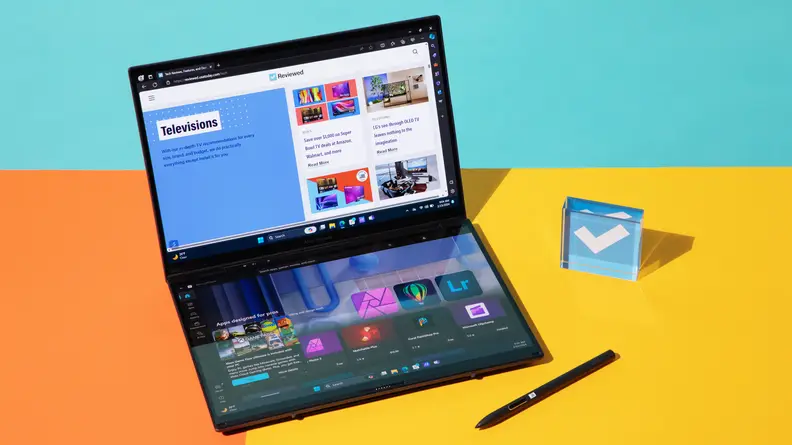Stylus pen sitting next to 2024 Asus Zenbook Duo laptop on top of orange and yellow split desk.