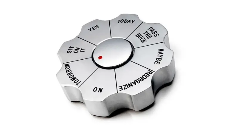 Silver paperweight that reads: "Today," "pass the buck," "maybe," "reorganize," "no," "tomorrow," "sit on it," and "yes."