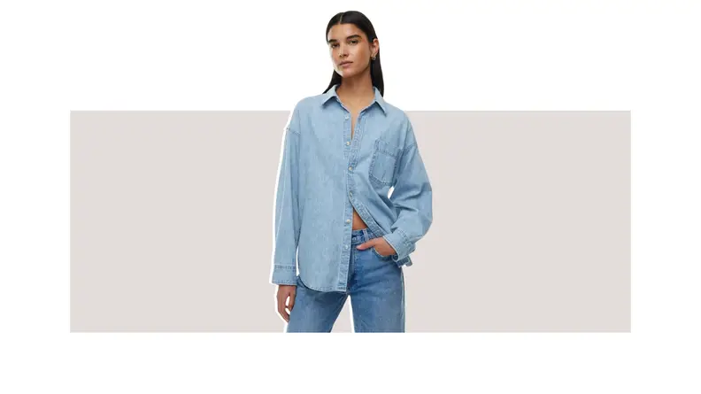 A model wearing a blue oversized denim shirt.