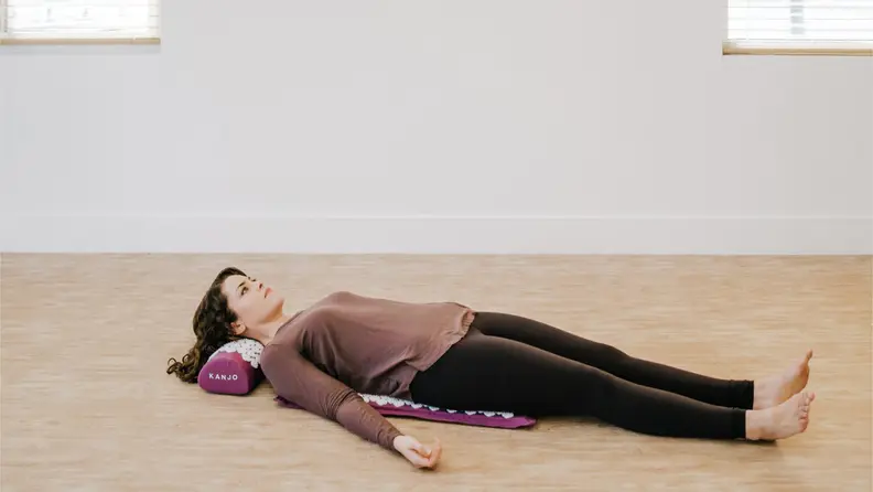 woman lying on kanjo acupressure mat.