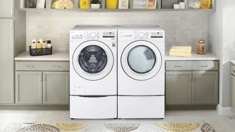 A white front-load washer and dryer pair in a laundry room setting surrounded by cabinets.