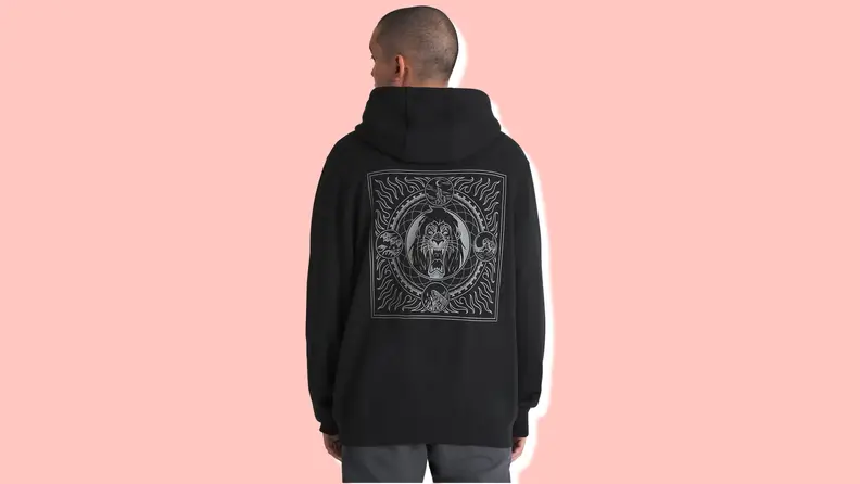 A man stands facing away from the camera, wearing a black hoodie sweatshirt with a graphic of Scar from "The Lion King"