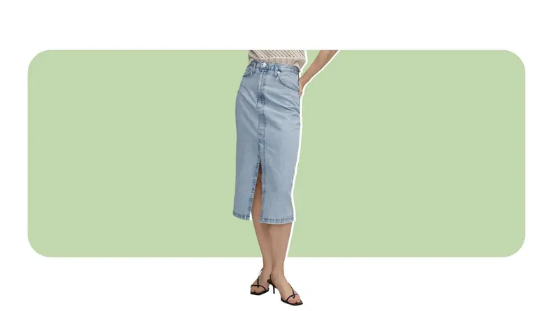 A model wearing a denim midi skirt with a slit in the front.