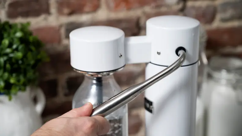 The lever movement is controlled by a rotational damper to allow for a more controlled released of pressure in the bottle.