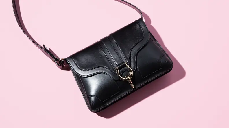 black shoulder bag on pink background