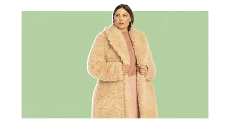 A model wearing a long fuzzy shearling coat.