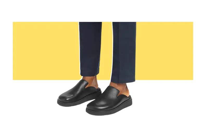 A model wearing black leather clogs.