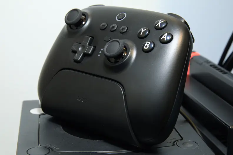 A black controller sitting upright in a charging dock