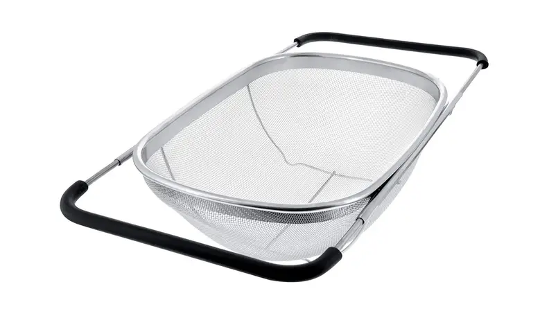 A stainless steel over the sink colander on a white background.