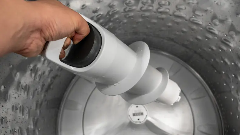 The pole agitator of the WTW8127LC being removed