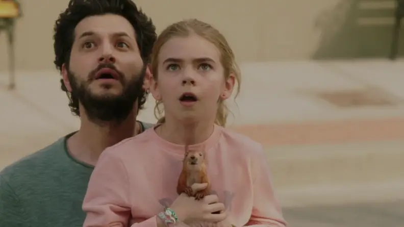 A still from the film Flora & Ulysses featuring Flora being held by her father.