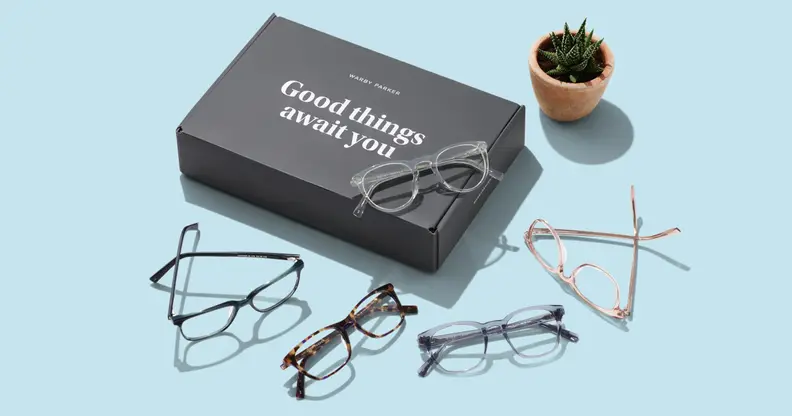 Warby Parker glasses on blue table next to box.