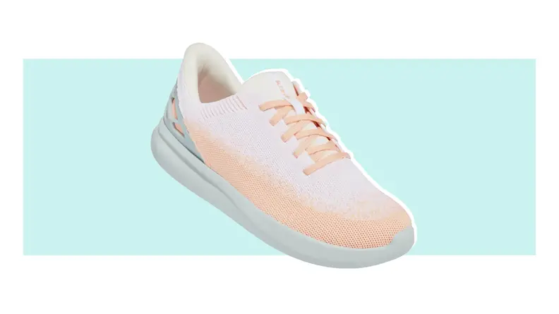 A single Kizik shoe in light peach and white positioned with the front tilted downward.
