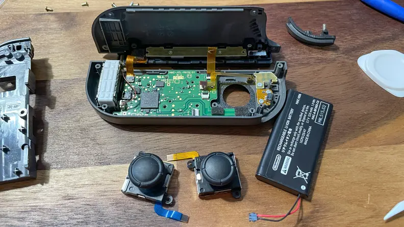 A Nintendo Switch joy-con disassembled so that the thumbstick modules can be replaced to fix stick drift.