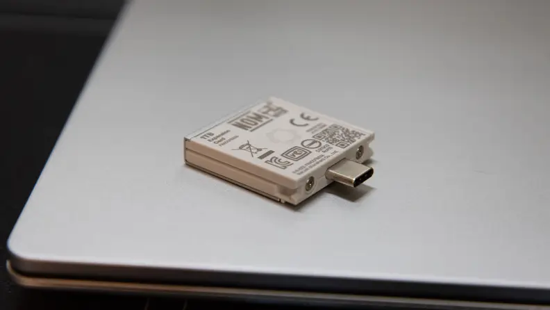An expansion card lies on the laptop's lid.