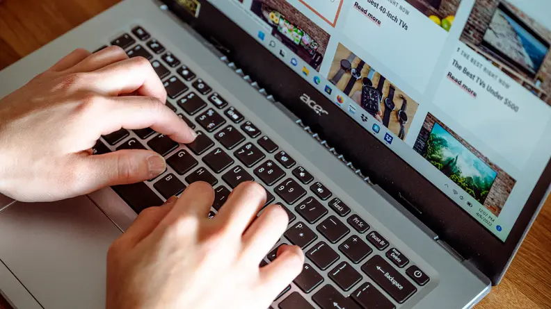 Person types on laptop keyboard