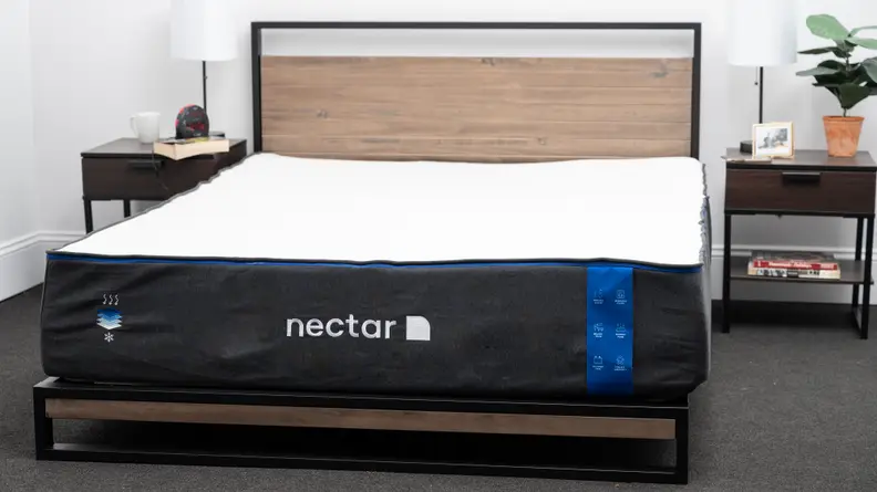 The Nectar mattress appears in a bedroom with bedside tables on either side.