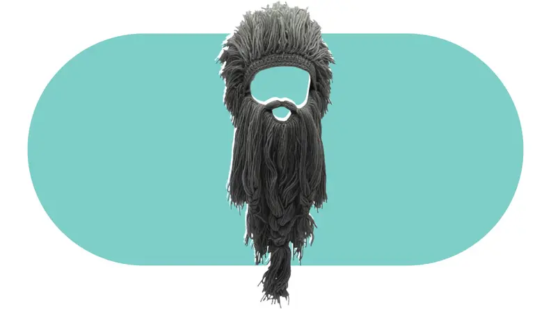 A knit hat made to look like a full head of hair with an attached oversized beard.