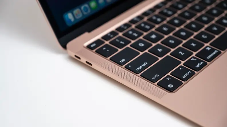 Close-up: A MacBook laptop has a built-in speaker along the edge of the keyboard, along with a pair of Thunderbolt 3 ports.