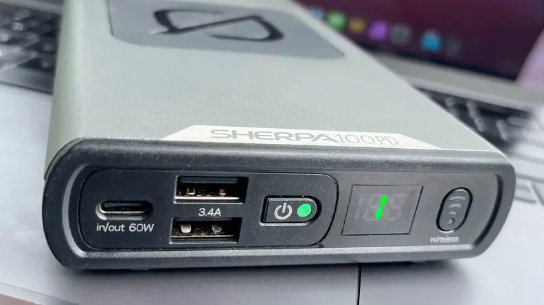 A GoalZero Sherpa 100PD sits on top of a MacBook Pro