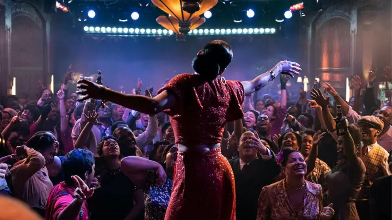 A still from the film The United States vs Billie Holiday featuring Billie Holiday as played by Andra Day performing onstage.