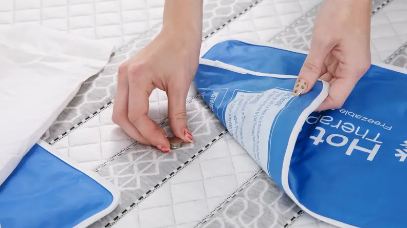 A person placing two heat sensors on the surface of the Leesa Sapira hybrid mattress.
