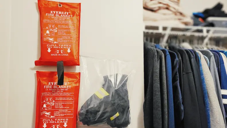 2-pack of XL Everlit Fire Blankets hanging up in closet next to gloves.