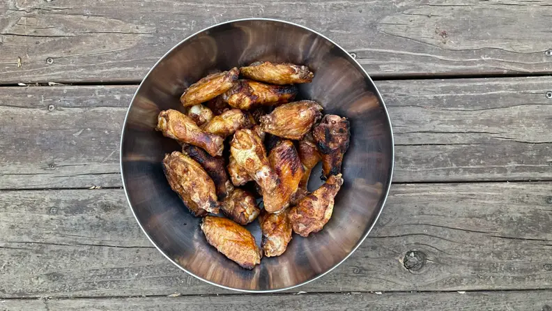 Smoked chicken wings inside a silver bucket.