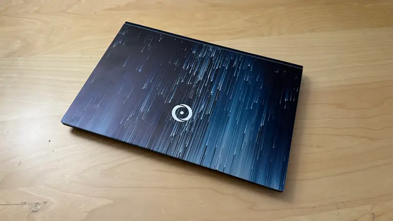 Origin EON14-S gaming laptop closed on top of wooden surface.