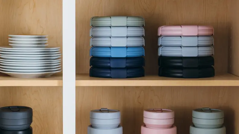 In a cabinet, stacks of Stojo bowls and cups are on display.