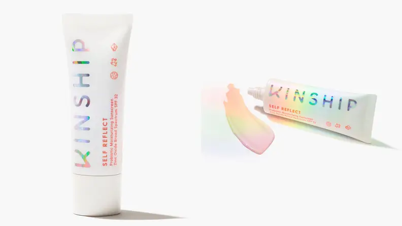 On the left: The Kinship Self Reflect Probiotic Moisturizing Sunscreen Zinc Oxide SPF 32 tube on a white background. On the right: The same tub lays on a white background with a beige swatch next to the product. There's a rainbow glow over the product.