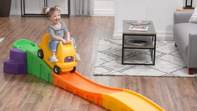 A girl laughs gleefully as she plays on her Step2 roller coaster.