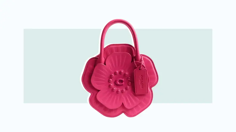 A small pink leather handbag that is designed to look like a flower.