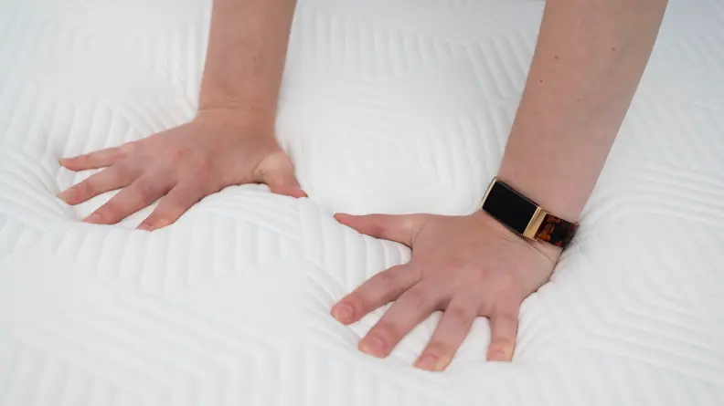 hands pressing into the surface of the Lucid mattress