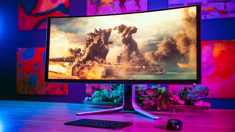 A monitor on top of a desk with a colored background