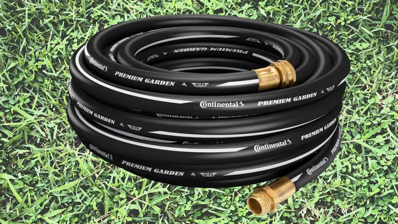 A black hose coiled on grass