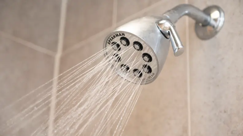 The Speakman S-2251 silver shower head shown spraying water.