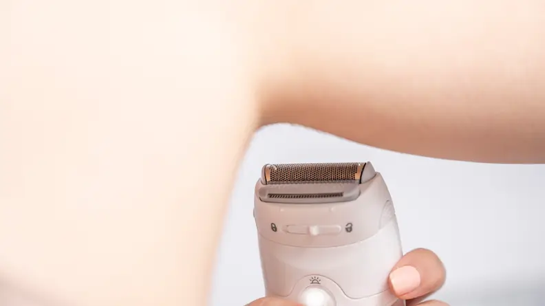 A person using the Braun Silk-Epil 9 on their leg.