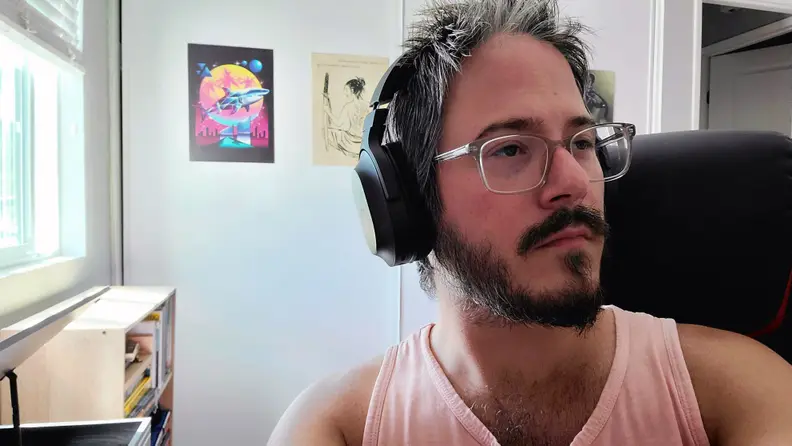 Man sitting in chair, wearing Razer Barracuda X
