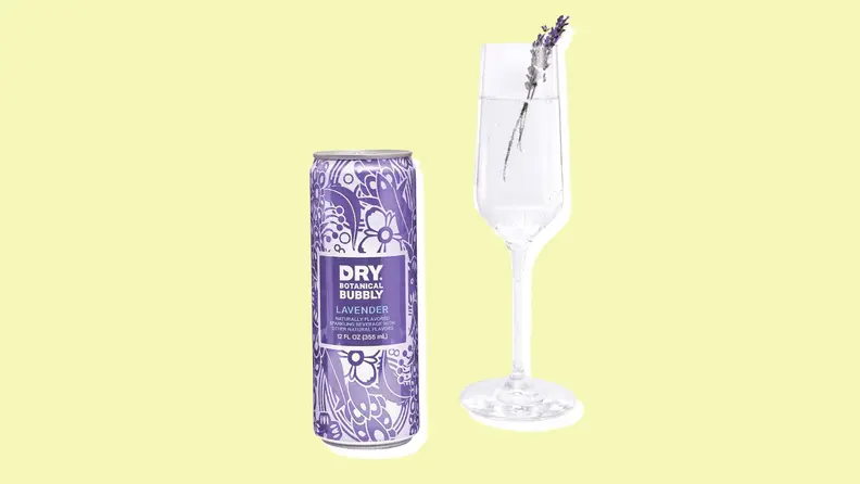 A can of Dry bubbly beside a flute garnished with lavender