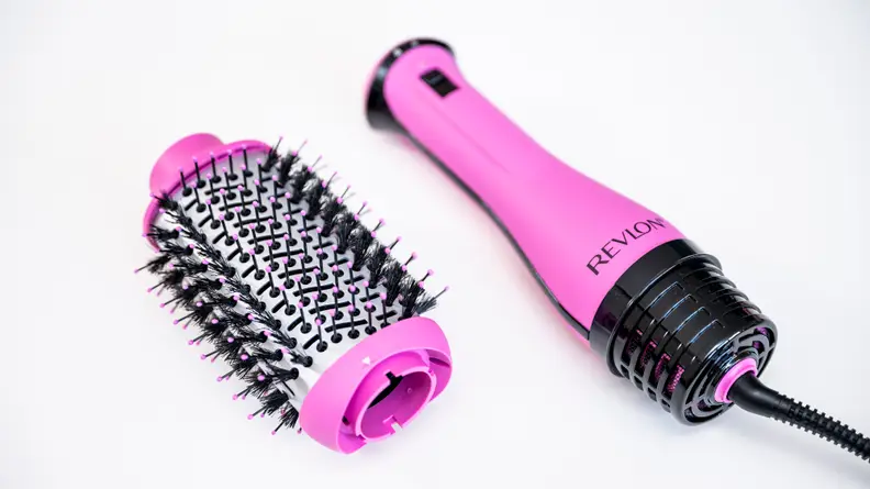 The Revlon hair dryer brush head and handle sitting detached on a white surface.