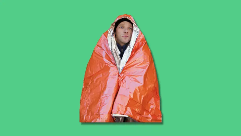 A man wrapped in thermal blanket.