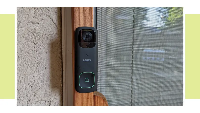 The Lorex 2K wireless doorbell hanging on the side of a home