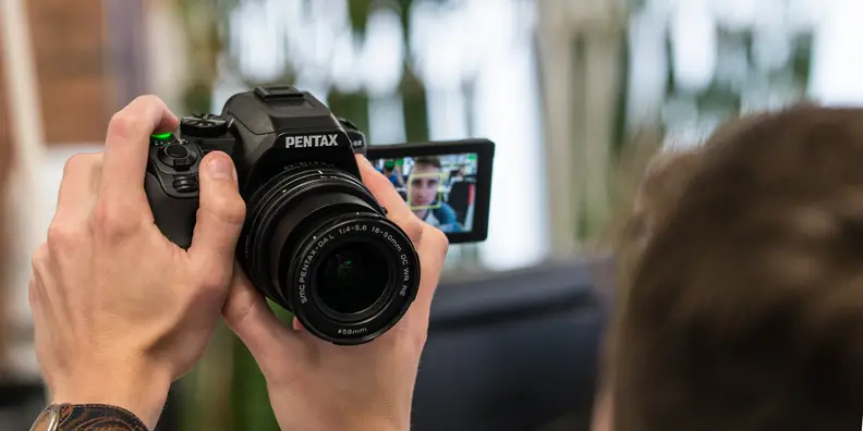 A photograph of the Pentax K-S2 used in selfie mode.
